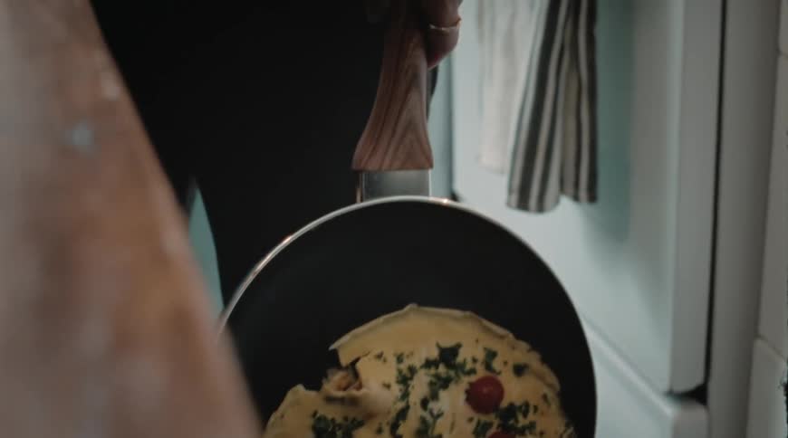 A person slowly drops food out of a pan