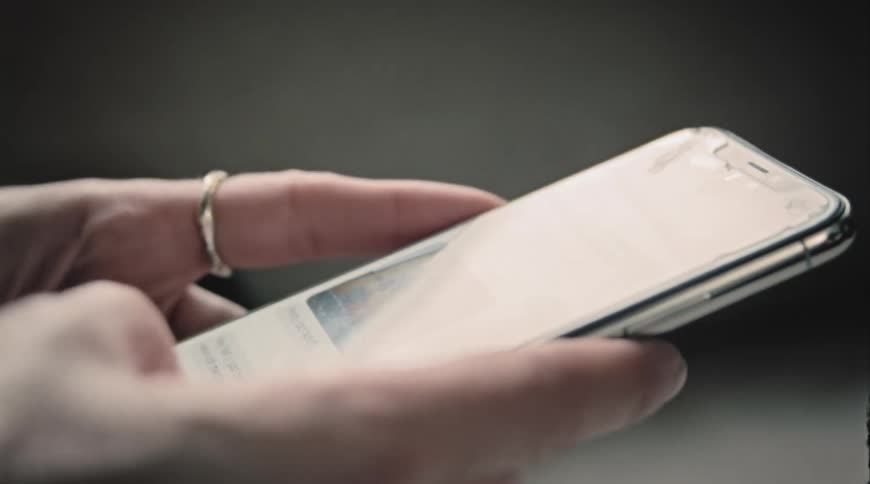 A person using their thumb to operate a smartphone