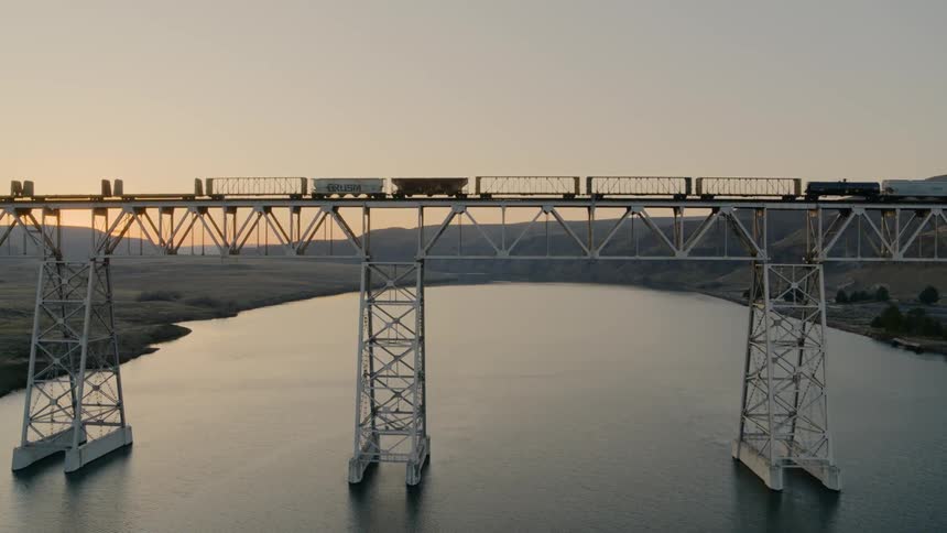 Slow push toward a cargo train on a high bridge
