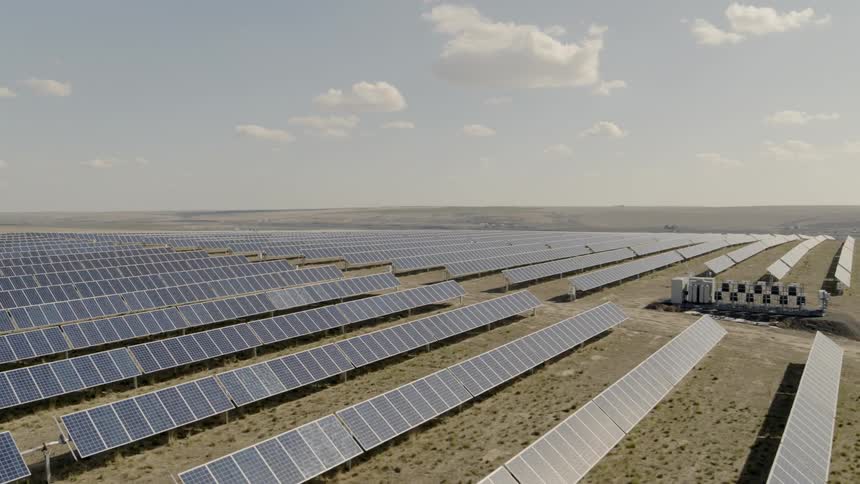 Rows and rows of solar panel arrays in a hot and sunny desert