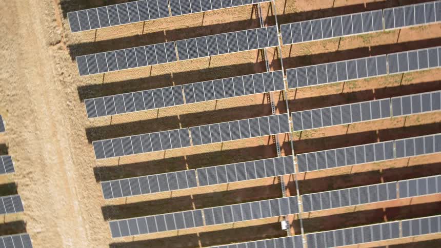 Dramatic twisting rise above solar farm panels on a sunny day