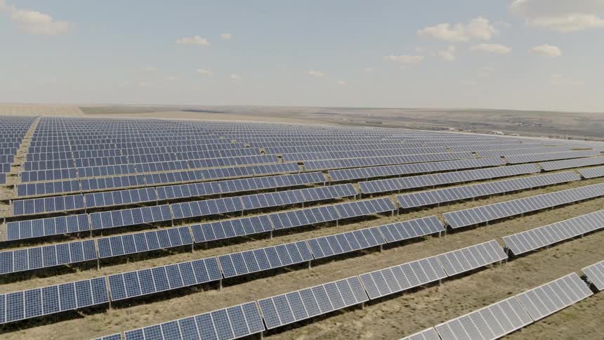 Subtle ascent over a large solar farm in a bright and sunny desert