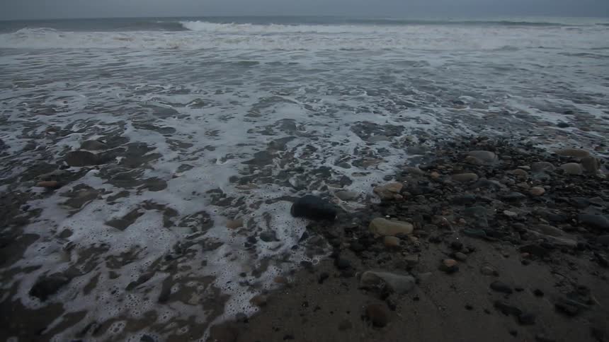 Waves rush onto the beach and then retract