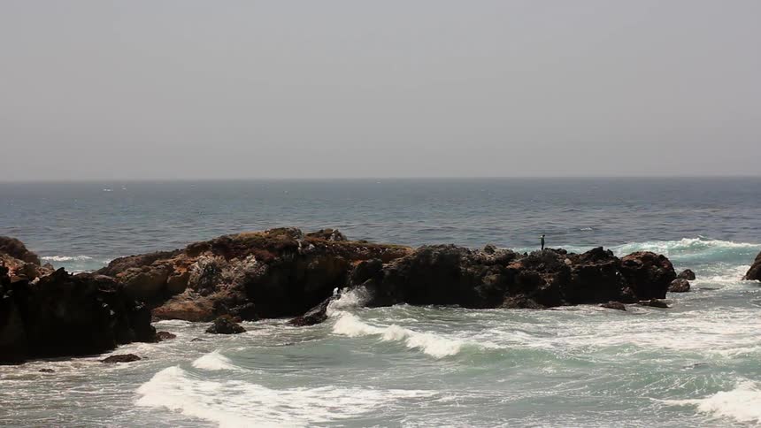 Ocean waves break and splash on the rocks