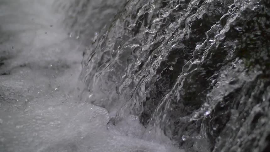 Close up of a waterfall splashing into a large body of water