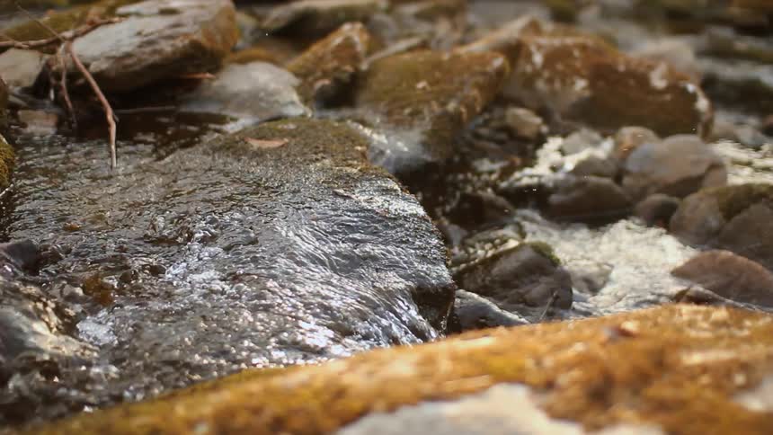 Water flowing over moss-covered rocks