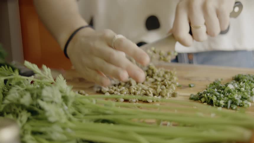 A woman chops vegetables with a knife