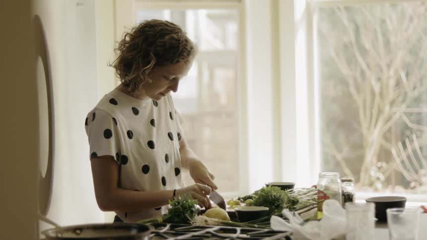 A woman chopping up food with a knife