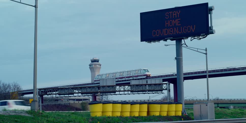A highway with a train overpass and an electric sign