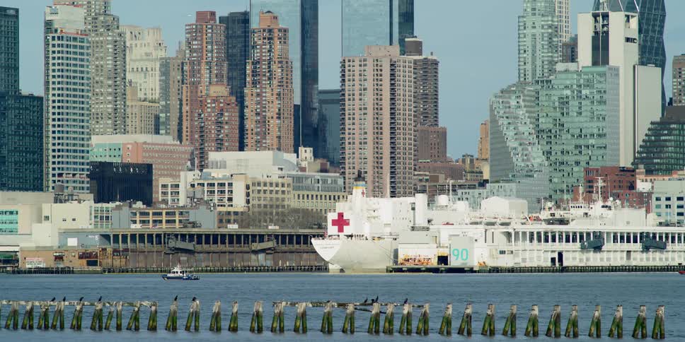 A river with boats and ships with the city skyline in the background