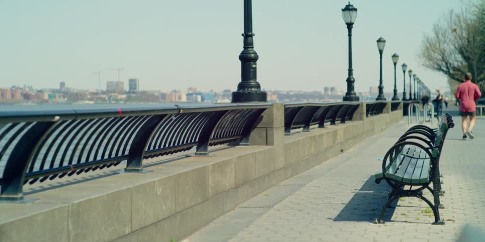 People running along a sidewalk overlooking the water