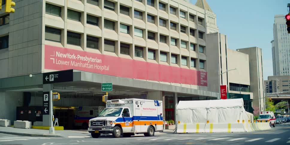 A hospital with an ambulance in front