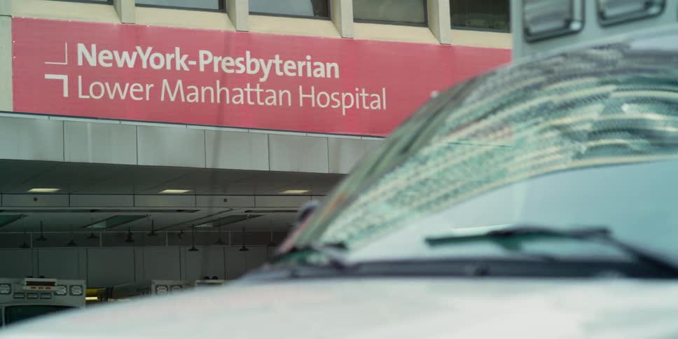 A person on a bike rides past the ambulance bay of the new york presbyterian hospital