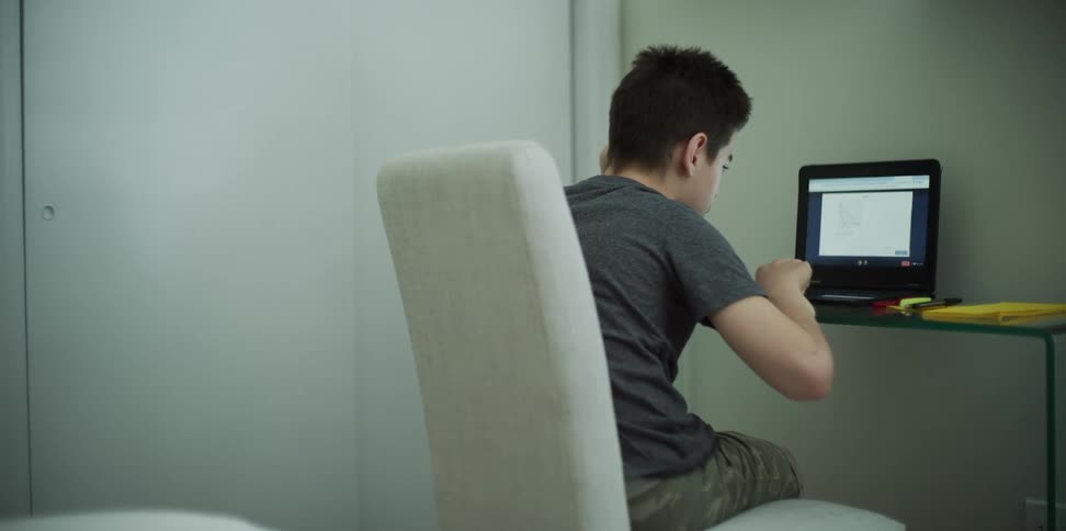 Boy doing homework on laptop at home