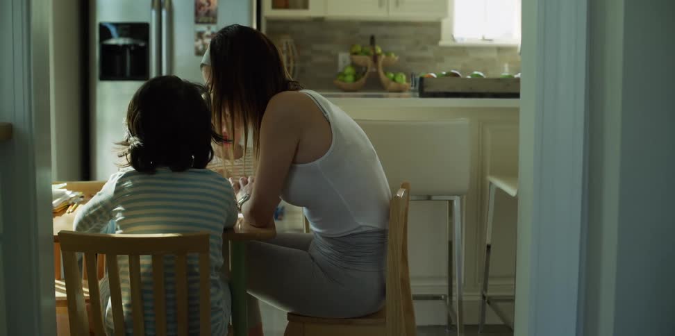 A mother and her children eat lunch at their kitchen table
