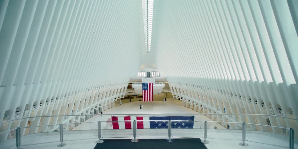 Only a few people walk in the empty oculus transportation hub