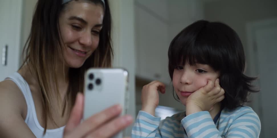 A woman and a girl take a picture with a smart phone