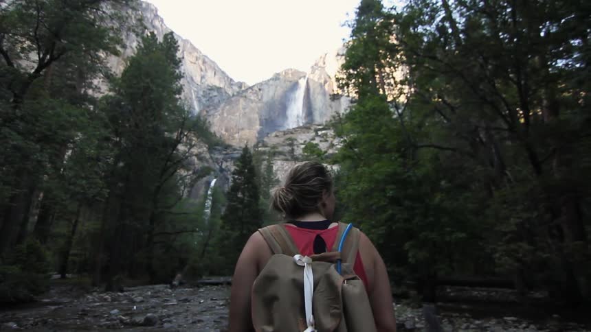 A woman looks at the mountain and forest scenery
