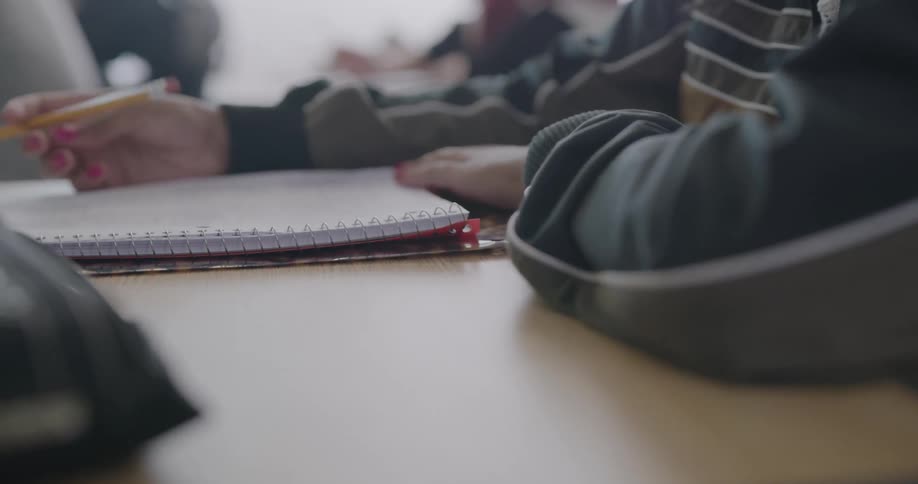 A person opens up a pencil case on a desk