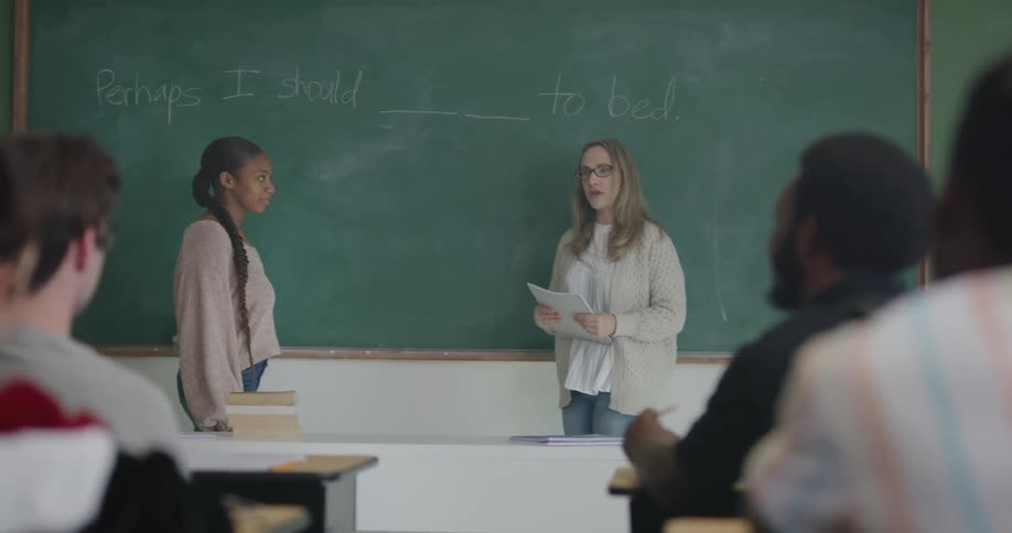 Teacher and student standing in front of class