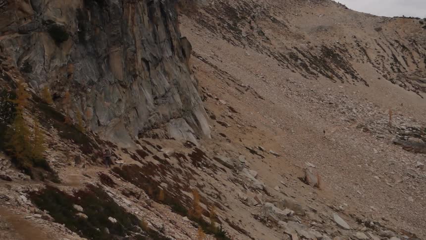 Someone hiking on a trail in a barren mountain range