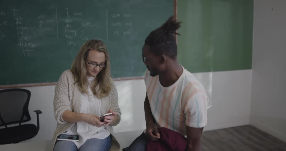 A teacher and student compare notes on their smart phones