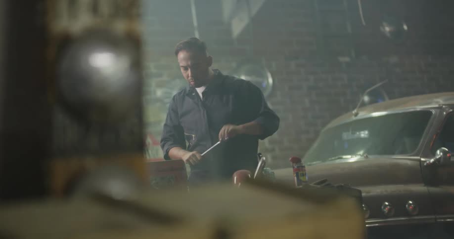 Car mechanic repairs an old car at the garage