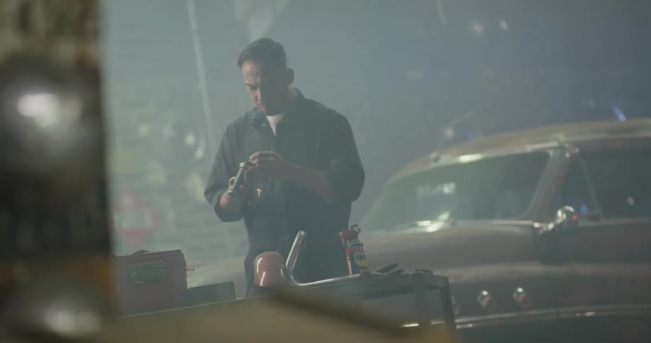A mechanic cleans a tool in an auto shop