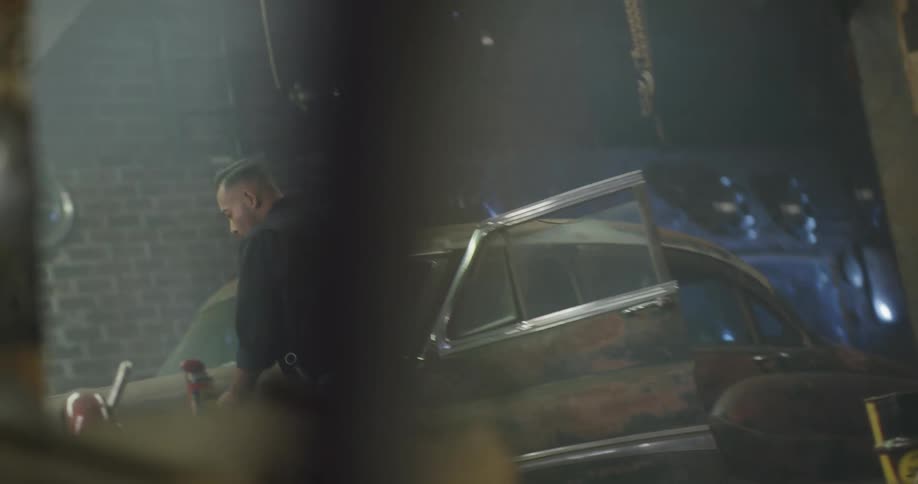 Car mechanic opens door of vintage car then props up the hood