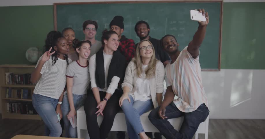 Black boy takes selfies with his friends in the classroom