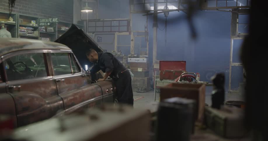 A mechanic working underneath the hood of a car