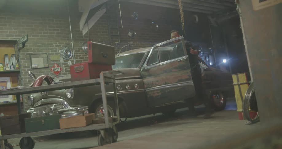 Car mechanic repairs an old car at the garage
