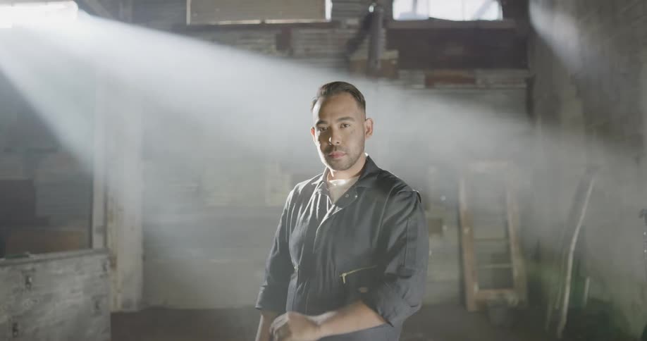 A mechanic uncrosses his arms and turns around and walks away