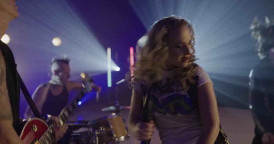 Rock band performs on stage with backing light show
