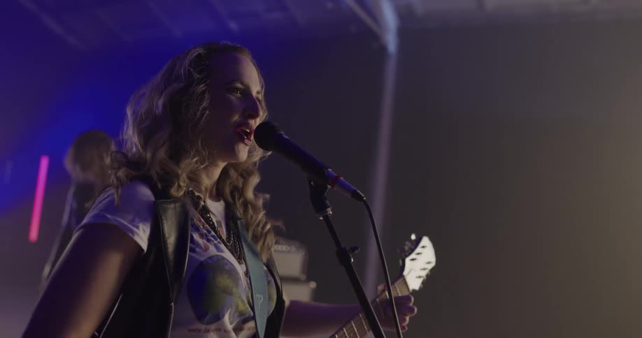 Rock band with female lead singer performs a concert on stage