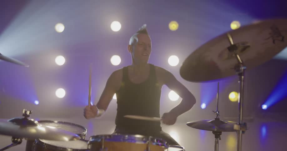 Lights shine behind a band playing on stage