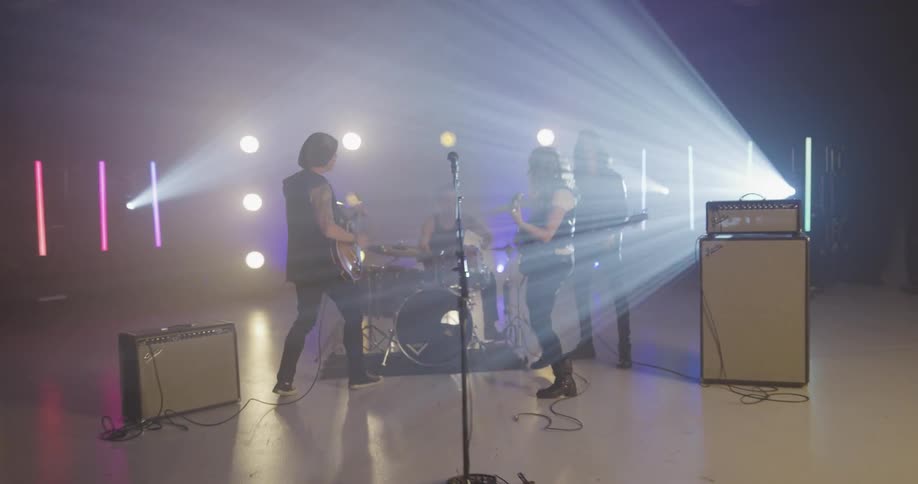 Rock band performs on stage with light show