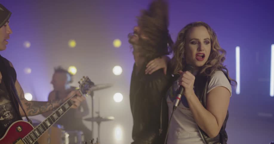 A rock band with a female lead singer performs on stage