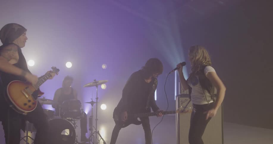 Rock band plays and performs on stage with light show