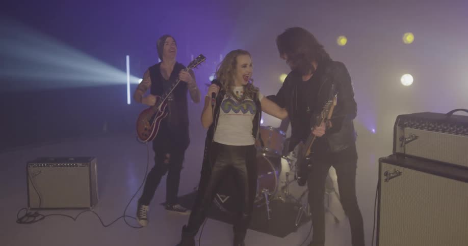 The members of a band congratulating one another on stage