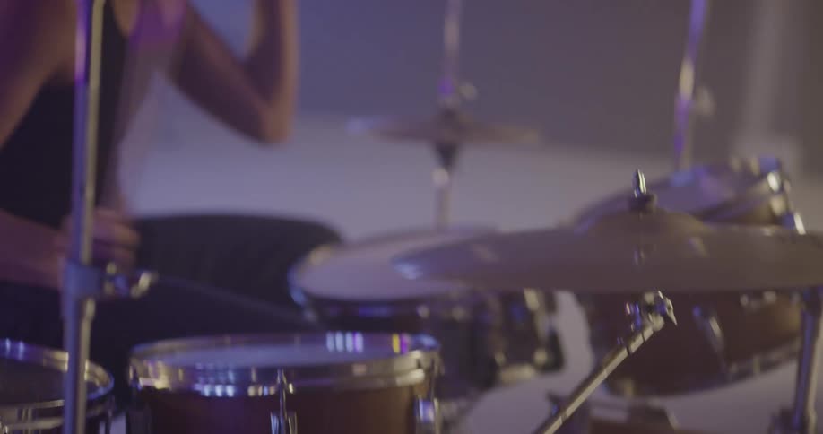 A drummer playing aggressively on the drum set