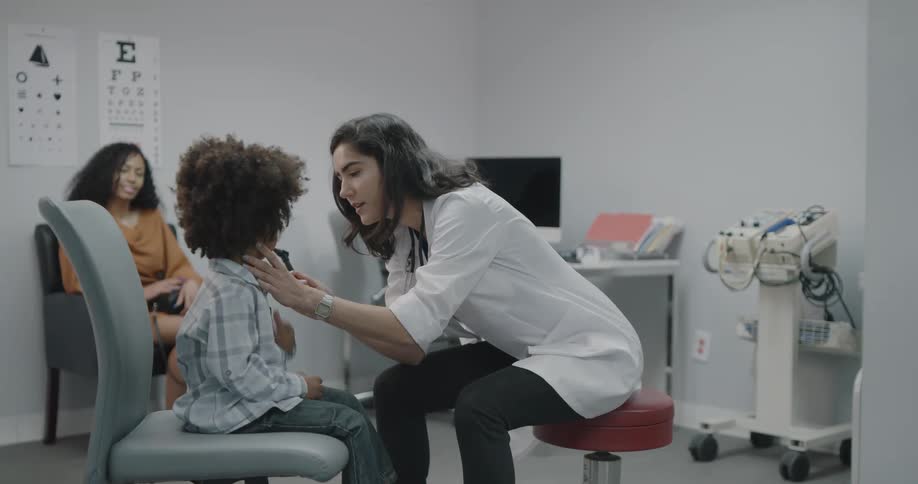 Female doctor treats a black toddler boy in a clinic