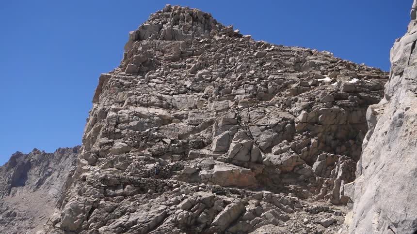 Someone hiking up a rocky mountain side
