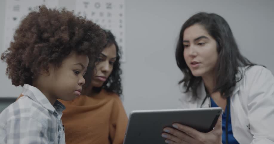 Doctor uses tablet to explain diagnosis to mother of child