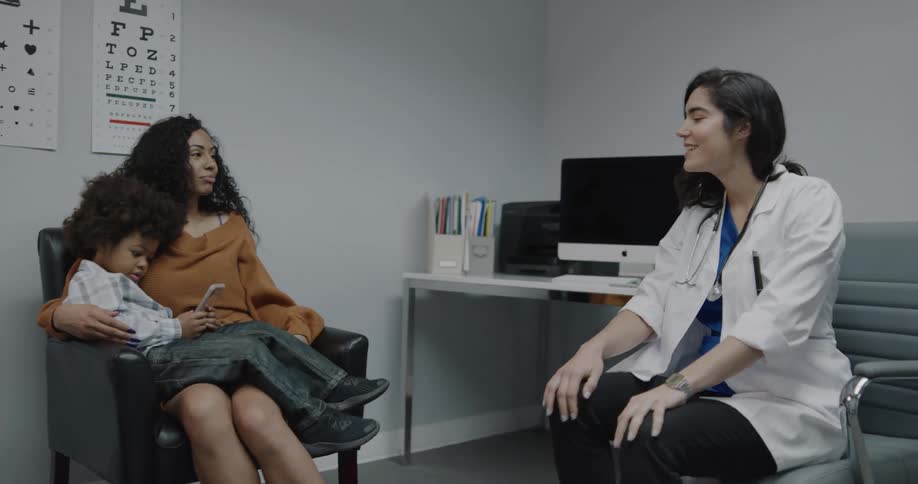 Doctor walks into office and talks patient