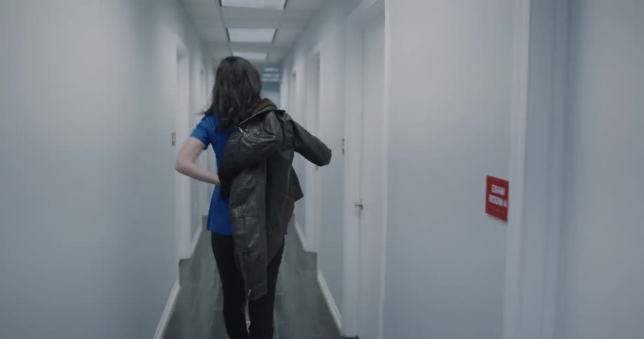 Female doctor puts on her leather jacket and leaves the clinic
