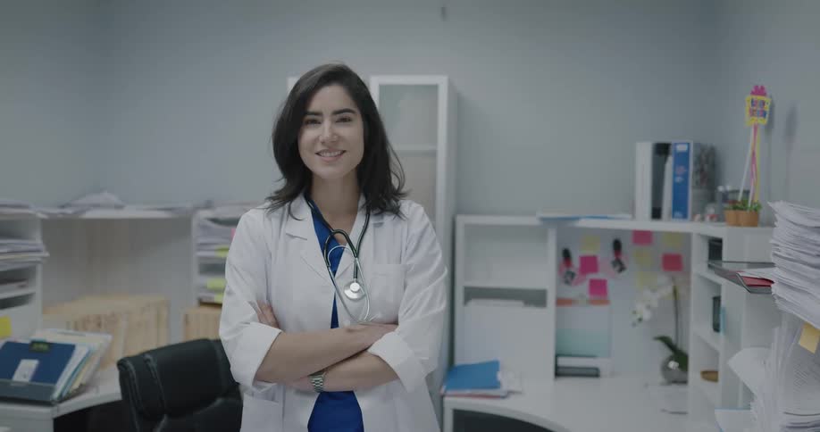 A doctor smiling into the camera in an office