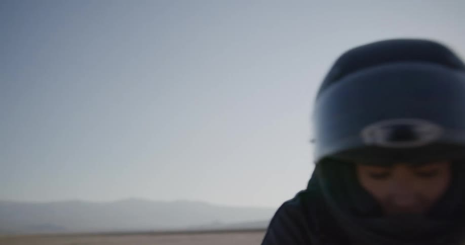 A woman suits up to ride her motorcycle in the desert