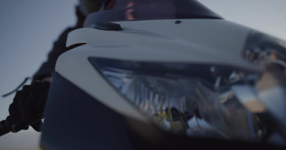 A woman puts on her sunglasses as she prepares to take off on her motorcycle