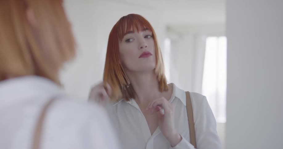 A woman checking herself in the mirror before leaving